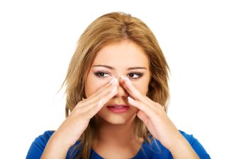 unsatisfied young woman touching her nose