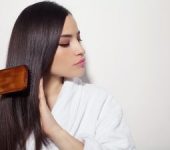 A young brunette woman brushing her long hair.