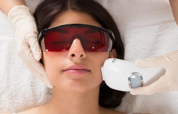 A young woman undergoing laser facial hair removal treatment in Beverly Hills, CA.