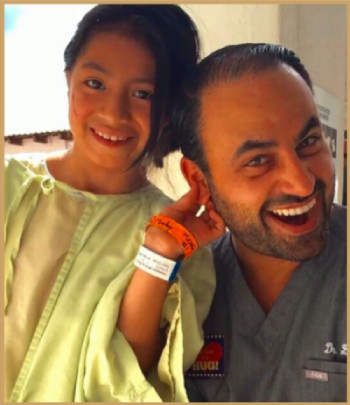 Dr. Ben Talei smiling with his young patient