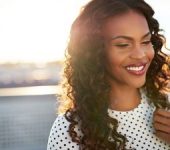 A happy Afro-American woman with beautifully shaped nose after Rhinoplasty in Beverly Hills, CA.