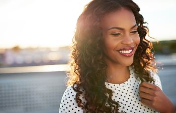 A happy Afro-American woman with beautifully shaped nose after Rhinoplasty in Beverly Hills, CA.