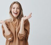 beautiful woman with blonde long hair looking at camera having excited and happy facial expression