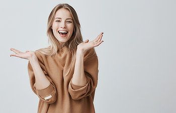 beautiful woman with blonde long hair looking at camera having excited and happy facial expression