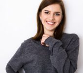 smiling brunette in a gray sweater