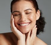 Face, beauty and satisfaction with a model black woman in studio on a gray background to promote natural skincare. Facial, wellness and makeup with an attractive young female happy with cosmetics