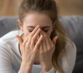 Close up thoughtful woman with closed eyes covered face in hands, feeling pain, having problem with relationships or health, headache, upset tired girl worried about future, making hard decision